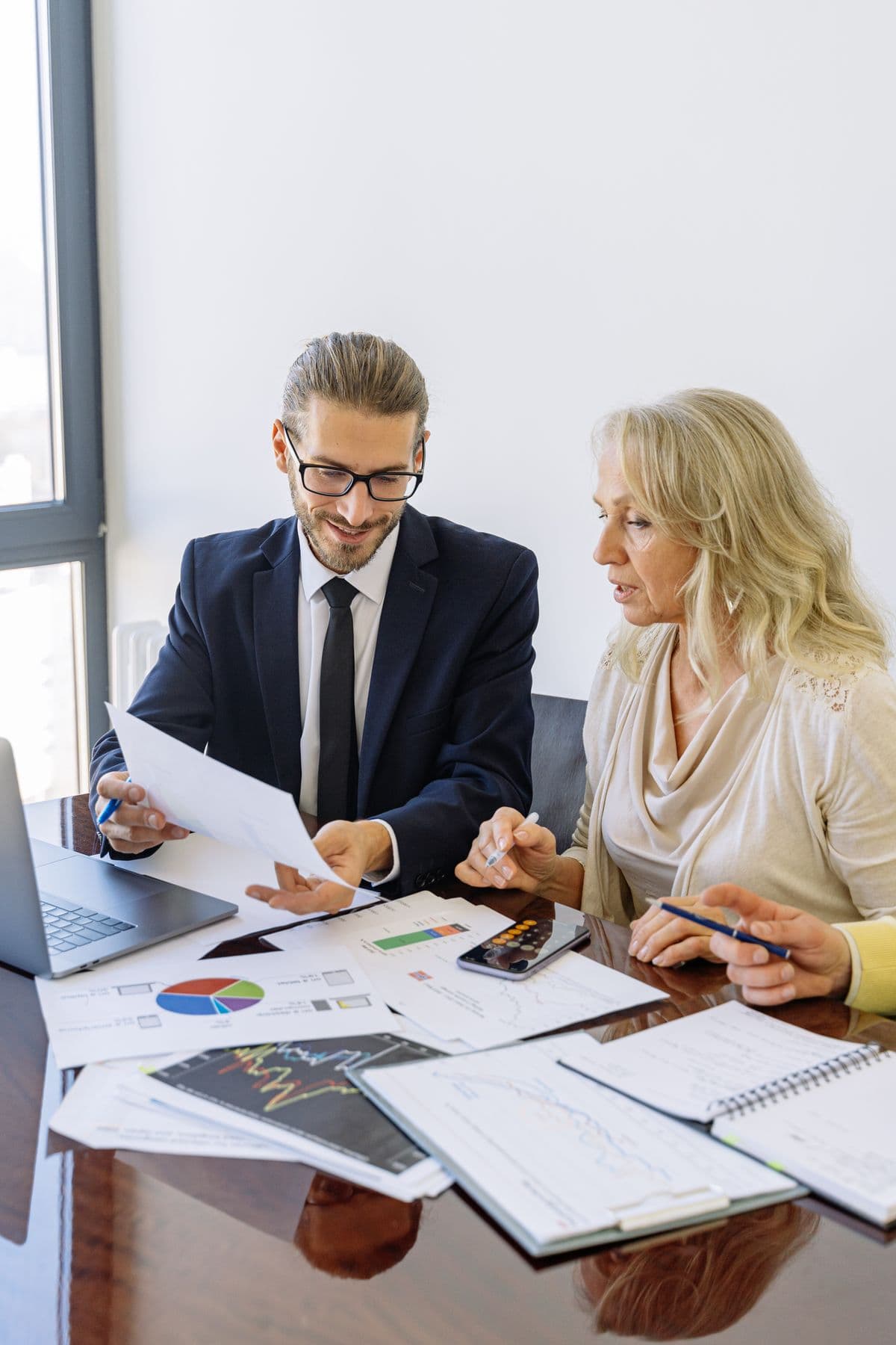Two people reviewing documents together during an office consultation